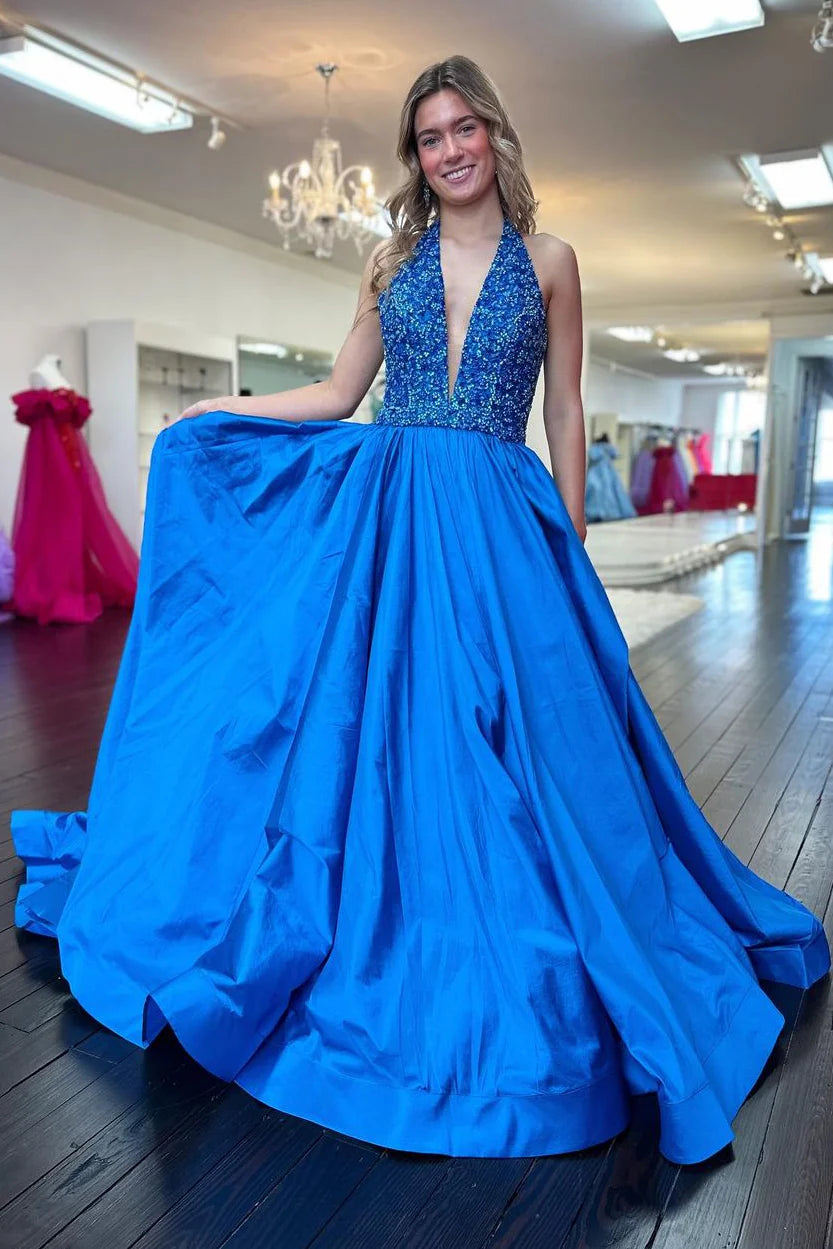 Model in blue A-line halter deep V-neck sequin satin prom dress with train, side view.