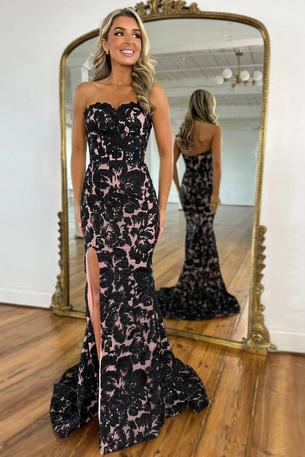 Black mermaid prom dress featuring a sweetheart neckline, intricate appliques, a high slit, and a dramatic train.