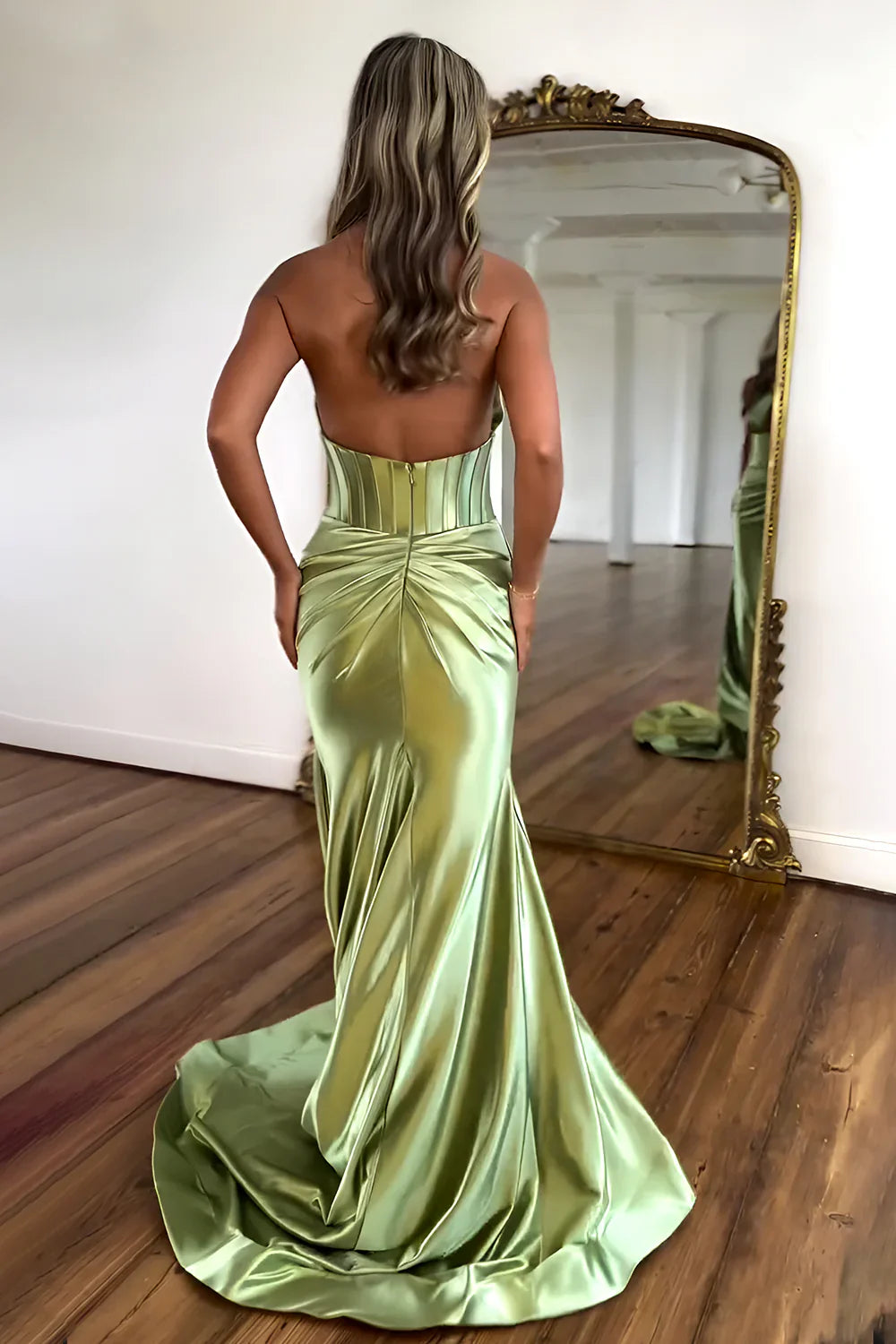 A woman posing in a backless halter neck satin mermaid prom dress.