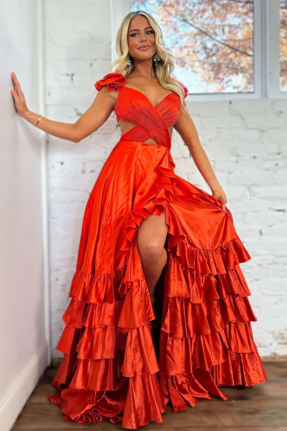 Vibrant coral red A-line prom dress with V-neck, cutout waist, tiered satin skirt, and high split.