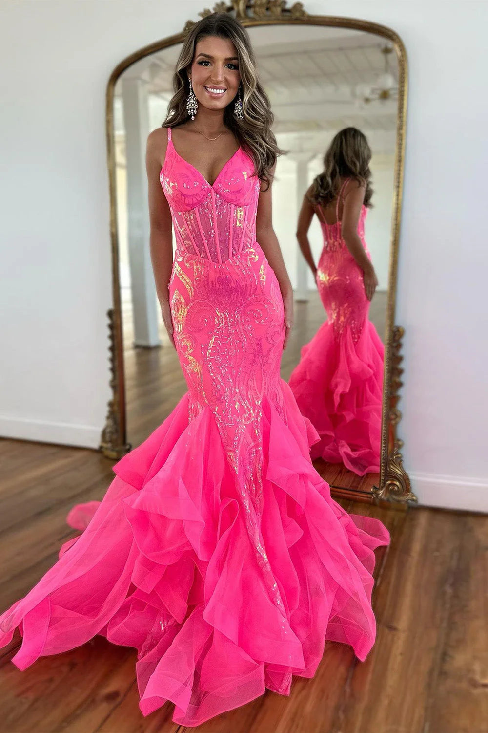 Hot pink sequin mermaid prom dress with spaghetti straps and ruffles, front view.